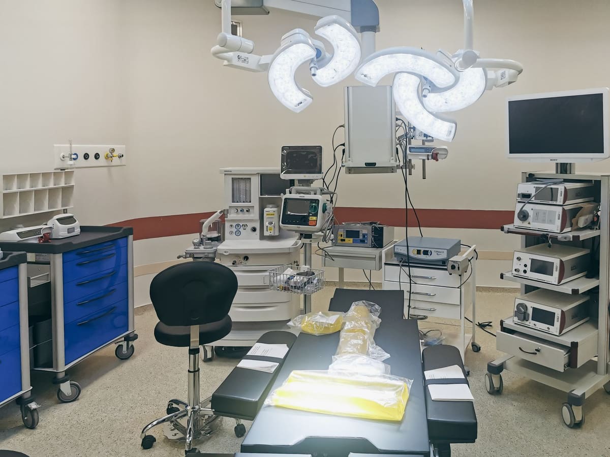Empty operating room with surgical lights, an operating table and equipment carts ready for the next case