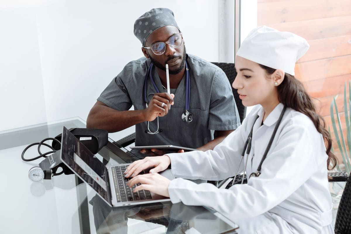 Two clinicians reviewing figures together on a laptop at a desk