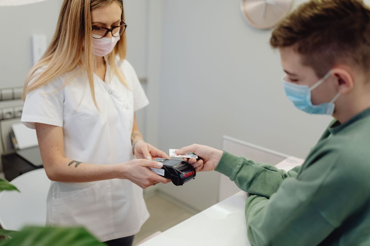 Patient paying by card at a clinic reception desk