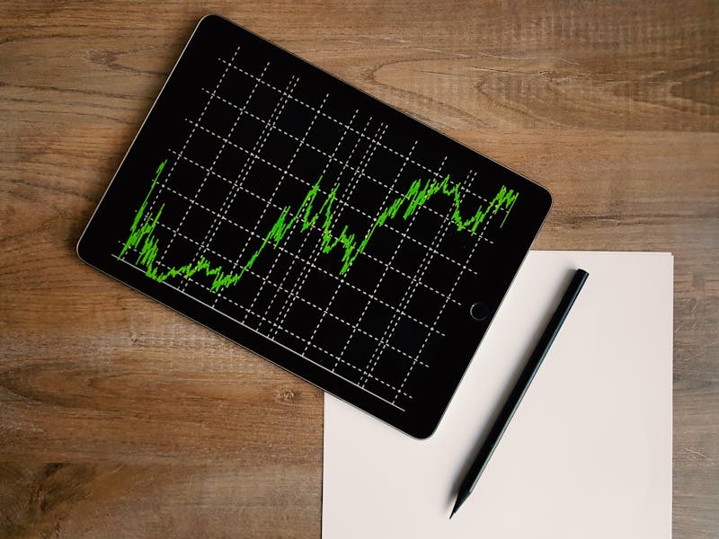 Tablet showing a trend chart on a wooden desk