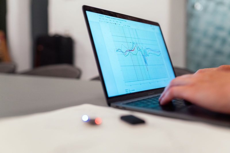 Analyst reviewing trend data on a laptop, reflecting the algorithm-driven claim review payers now run