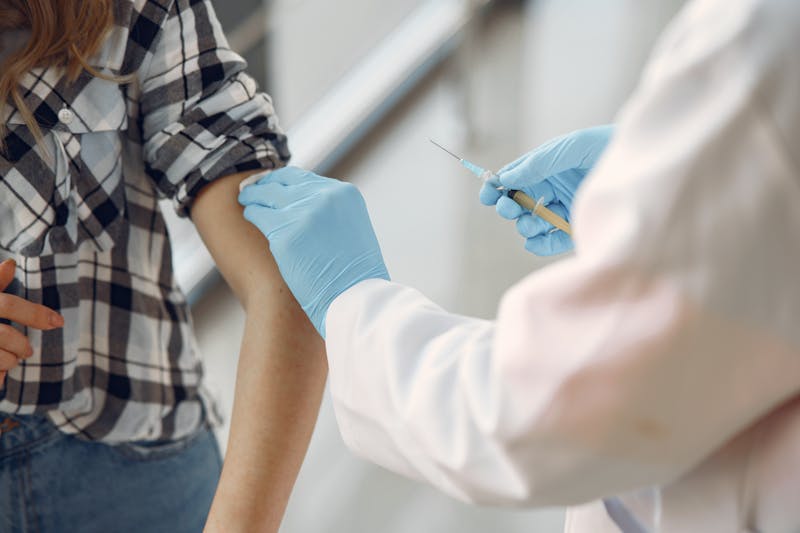 Healthcare provider administering care to female patient in clinical setting