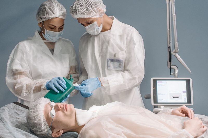 Two clinicians working together as an anesthesia care team, administering anesthesia to a patient before a procedure
